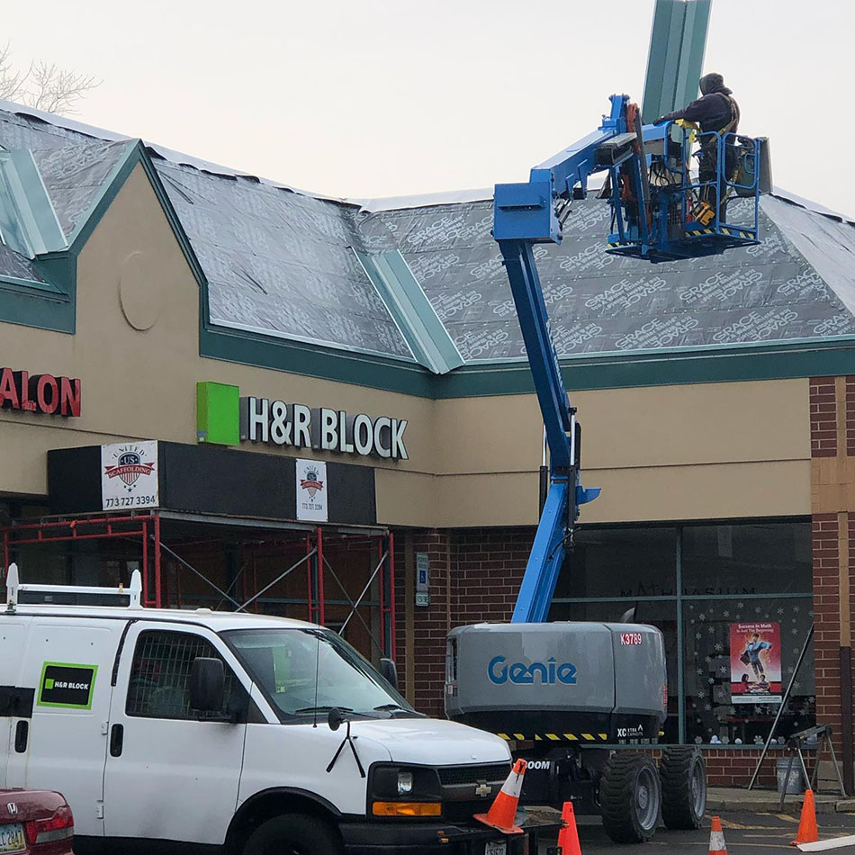 Contractor on a sloped roof getting ready to install GAF red asphalt shingles on a residential home